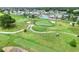 Aerial view of the golf course with verdant fairways, manicured greens, sand traps and golf carts, inviting residents to play at 5725 Mallard Dr, Lakeland, FL 33809