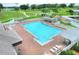 Aerial view of a community swimming pool and lounge area surrounded by lush landscaping at 5725 Mallard Dr, Lakeland, FL 33809