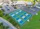 Aerial view of a tennis courts with shaded benches, surrounded by green lawns and mature trees, and a parking lot at 5725 Mallard Dr, Lakeland, FL 33809