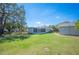 Grassy backyard with a shed, screen porch, and wood fence at 624 Woodward St, Lakeland, FL 33803