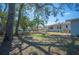 View of the backyard showing the grassy lawn, trees, fence, and house at 624 Woodward St, Lakeland, FL 33803