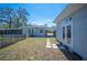 View of the house and shed from the backyard with a pathway made of square pavers and a wooden fence at 624 Woodward St, Lakeland, FL 33803