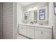 Bathroom featuring dual sinks, marble countertop, white cabinets, and subway tile at 624 Woodward St, Lakeland, FL 33803