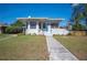 Charming bungalow featuring light blue door, a manicured lawn and a stone-clad retaining wall at 624 Woodward St, Lakeland, FL 33803