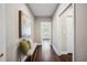 Entryway hallway featuring hardwood floors, neutral paint colors, and accent bench with decorative pillows at 624 Woodward St, Lakeland, FL 33803