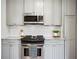 Updated kitchen featuring stainless steel microwave and range, granite countertops and white tile backsplash at 624 Woodward St, Lakeland, FL 33803