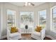 Sunroom featuring two chairs with decorative pillows and three large windows at 624 Woodward St, Lakeland, FL 33803