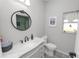 Bathroom features a round mirror, decorative tile floor, and a single sink marble vanity at 6329 Torrington Cir, Lakeland, FL 33811