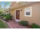 Inviting front entrance with a decorative wreath, a small window and brick walkway with manicured garden at 6329 Torrington Cir, Lakeland, FL 33811