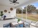 Relaxing sunroom features a ceiling fan, comfortable seating, and views of the spacious backyard at 636 Sw 77Th Cir, Ocala, FL 34474