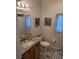 Charming bathroom featuring a granite vanity top, wooden cabinets, and framed artwork at 6397 Torrington Cir, Lakeland, FL 33811