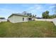 View of the backyard with a white fence, green grass, and a playset for the  at 7211 Scenic Hills Blvd, Lakeland, FL 33810