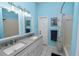 Well-lit bathroom with double sinks, light gray counter, and tub/shower combo at 7211 Scenic Hills Blvd, Lakeland, FL 33810