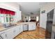 Open kitchen featuring stainless steel appliances, white cabinets, and seamless flow into the living area at 7211 Scenic Hills Blvd, Lakeland, FL 33810