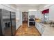 Modern kitchen with wood-look flooring, stainless steel appliances, and a view into the adjacent dining room at 7211 Scenic Hills Blvd, Lakeland, FL 33810