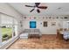 Open-concept living room with wood-look flooring, comfortable seating, and built-in display shelving at 7211 Scenic Hills Blvd, Lakeland, FL 33810