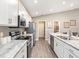 This open kitchen features modern stainless steel appliances, white cabinets and stylish countertops at 722 Bentley North Loop, Auburndale, FL 33823