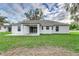 Backyard view showcasing a covered patio and a pristine lawn, perfect for outdoor entertaining at 750 W Vine St, Bartow, FL 33830