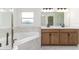 Spa-like bathroom with double vanities, a large soaking tub, and a glass-enclosed shower at 750 W Vine St, Bartow, FL 33830