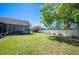 Well-maintained lawn with lush greenery, white fencing, and screened-in patio at 940 Ashton Oaks Cir, Lakeland, FL 33813