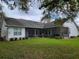 A view of the home's screened in back porch, with a beautiful grassy area and landscape at 940 Ashton Oaks Cir, Lakeland, FL 33813