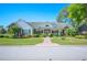 Charming single-story home featuring a manicured lawn, brick accents, and a welcoming front porch at 940 Ashton Oaks Cir, Lakeland, FL 33813