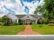 Charming single-story home featuring a brick walkway, manicured lawn, and a welcoming front porch at 940 Ashton Oaks Cir, Lakeland, FL 33813