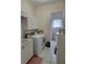 Laundry room with white cabinets and modern appliances, leading to another bathroom at 940 Ashton Oaks Cir, Lakeland, FL 33813