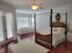 Spacious main bedroom with hardwood floors, four poster bed, and french doors to outside at 940 Ashton Oaks Cir, Lakeland, FL 33813