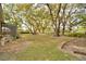 Expansive backyard featuring mature trees, lush grass, and room for outdoor activities and entertaining at 1 Lake Eloise Ln, Winter Haven, FL 33884