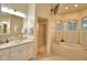 Elegant bathroom featuring a glass shower, garden tub, and vanity with glass bowl sinks at 1 Lake Eloise Ln, Winter Haven, FL 33884