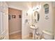 Bathroom showing the pedestal sink, toilet, and nautical decor and door at 1 Lake Eloise Ln, Winter Haven, FL 33884