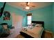 Vibrant bedroom with light-blue walls, cozy chair, and a ceiling fan at 1 Lake Eloise Ln, Winter Haven, FL 33884