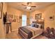 Bedroom with a ceiling fan and a bed with neutral bedding and many decorations at 1 Lake Eloise Ln, Winter Haven, FL 33884