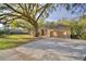 Spacious driveway leading to a tan single-story home with an attached two-car garage at 1 Lake Eloise Ln, Winter Haven, FL 33884