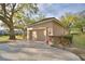 Spacious two-car garage with a concrete driveway, surrounded by lush landscaping and mature oak trees at 1 Lake Eloise Ln, Winter Haven, FL 33884