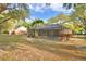 Relaxing backyard with a screened-in pool, surrounded by mature trees and lush landscaping at 1 Lake Eloise Ln, Winter Haven, FL 33884