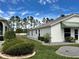 This home has a manicured lawn and mature landscaping, with a partial view of the home's exterior at 1155 Motorcoach Dr, Polk City, FL 33868