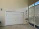 Attached garage with white door and wall lighting at 1155 Motorcoach Dr, Polk City, FL 33868
