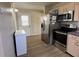 Bright kitchen features stainless steel appliances, wood flooring, and a door leading outside at 1155 Motorcoach Dr, Polk City, FL 33868