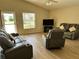 Spacious living room with neutral decor, vinyl floors, and ample seating with a large TV at 1155 Motorcoach Dr, Polk City, FL 33868