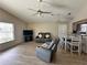 Inviting living room with wood-look floors, vaulted ceiling and open layout to dining area at 1155 Motorcoach Dr, Polk City, FL 33868