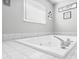 Bright bathroom featuring a soaking tub with white tile surround at 1310 Parker Rd, Lakeland, FL 33811
