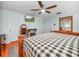 Bedroom with a fireplace, ceiling fan, wood floors, and plaid bedding at 1310 Parker Rd, Lakeland, FL 33811