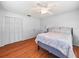 Bedroom with a ceiling fan, wood floor, closet, and a cozy bed at 1310 Parker Rd, Lakeland, FL 33811