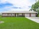 Charming brick home with well-maintained lawn, flower beds, and a three-car garage at 1310 Parker Rd, Lakeland, FL 33811