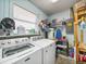 Functional laundry room featuring a washing machine and dryer with shelving for storage and supplies at 1310 Parker Rd, Lakeland, FL 33811