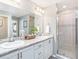 Bright bathroom features dual sinks, vanity with marble countertop, and glass-enclosed shower at 1746 Burrows Ave, Lakeland, FL 33811