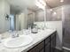 Modern bathroom with double sink vanity, granite counters, large mirror, and tile shower enclosure at 1758 Burrows Ave, Lakeland, FL 33811