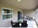 Spacious covered patio with outdoor seating, backyard view, and neutral colors at 1758 Burrows Ave, Lakeland, FL 33811
